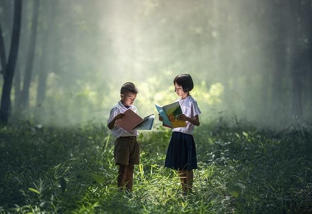 learning & learnings: a girl and a boy reading books in the forest